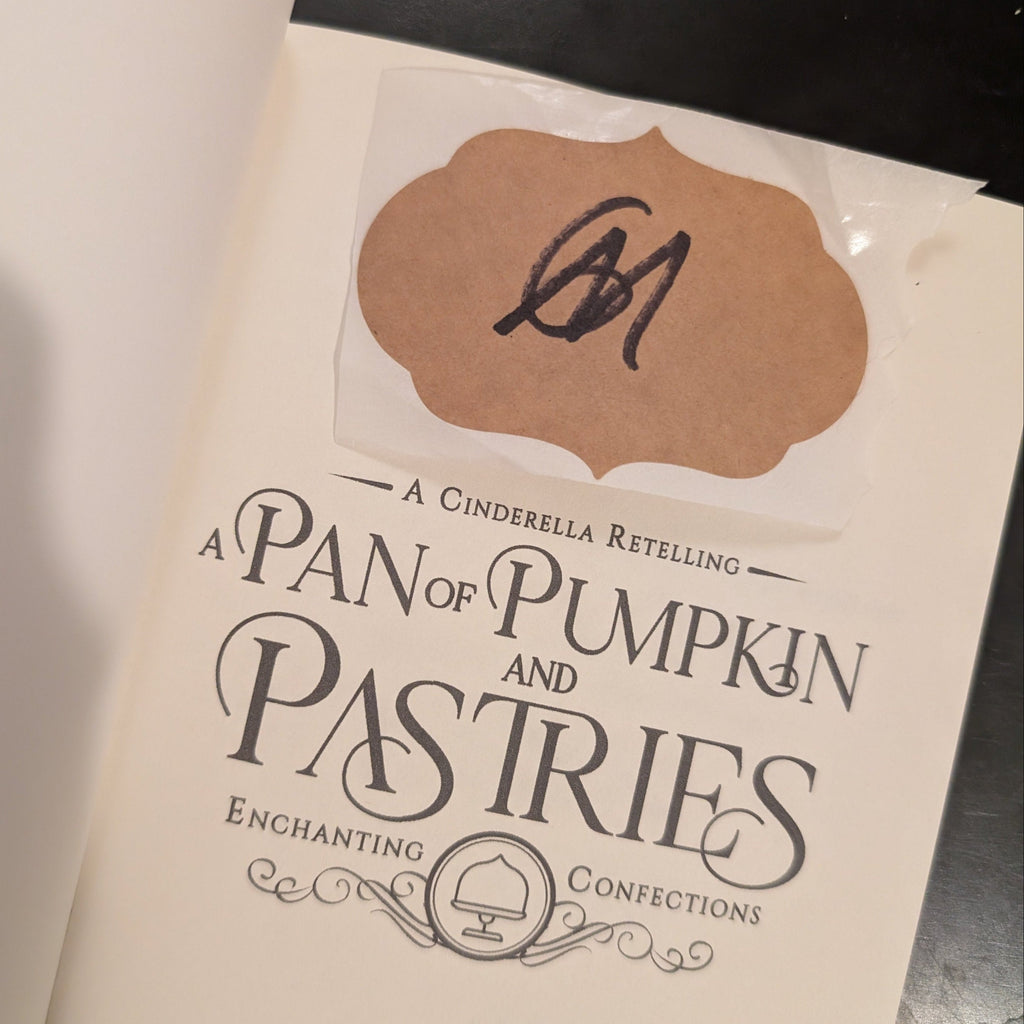 Book titled 'A Pan of Pumpkin Pastries' by A.G. Marsh on a metallic surface.
